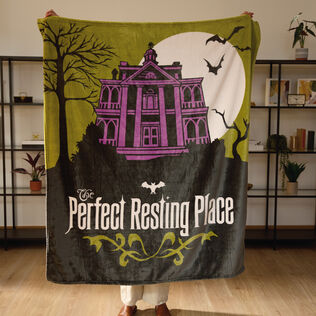 A blanket featuring a creepy scene of Disneys Haunted Mansion.